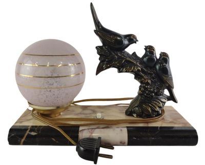 a lamp that is sitting on a book with a bird figurine next to it