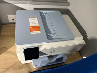 a printer sitting on top of a desk next to a blue chair