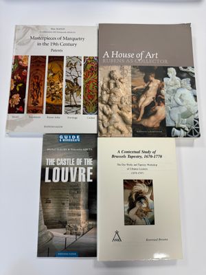 trois livres posés sur une table, à côté d'un clavier et d'une souris
