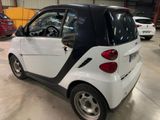 a smart car parked in a garage with other cars