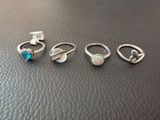 four rings with oplite stones on them sitting on top of a leather surface