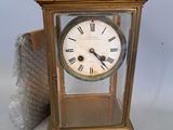 a gold clock with roman numerals on the face