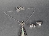 un collier, des boucles d'oreilles et une bague en argent, sertis d'incrustations d'oplite