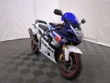 une moto bleue et blanche garée sur un sol à carreaux noirs et blancs