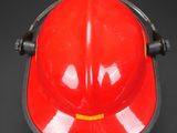 a red fireman ' s helmet on a black background