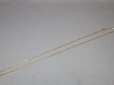a close up of a gold chain on a white surface