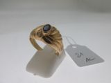l'image d'une bague en or ornée d'une pierre bleue