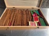 une boîte en bois remplie de différents types de stylos et de crayons