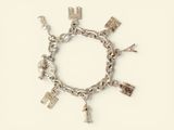 a silver bracelet with charms on it on a white surface