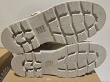 the sole of a pair of white shoes on top of a cardboard box
