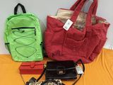 trois porte-monnaie et un sac à main posés sur un lit
