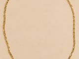 un collier à chaîne en or sur fond beige