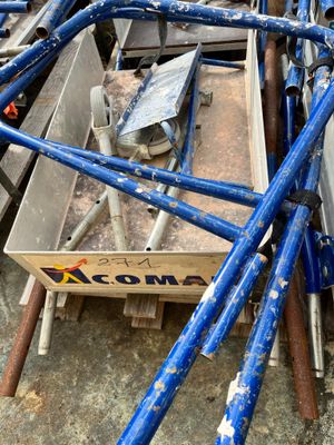 a pile of blue pipes sitting on the ground next to a box