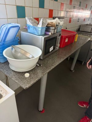 a woman standing in a kitchen next to a counter with a bowl on it