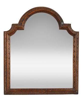 a large wooden mirror with an ornate design on the top