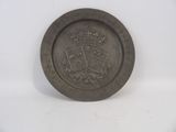une vieille plaque métallique sur laquelle figurent une couronne et des cartes à jouer