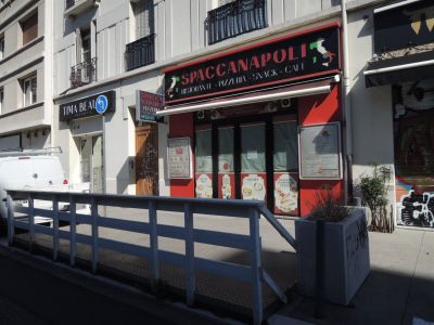 des bâtiments donnant sur une rue, devant lesquels est garée une camionnette blanche