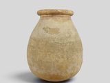 a small vase with a lid on a gray surface