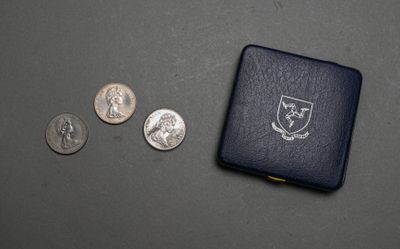 une petite boîte noire contenant des pièces de monnaie et un petit étui à pièces