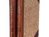 an old pair of books sitting next to each other on a white surface