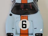 a model of a blue and orange race car on a white surface