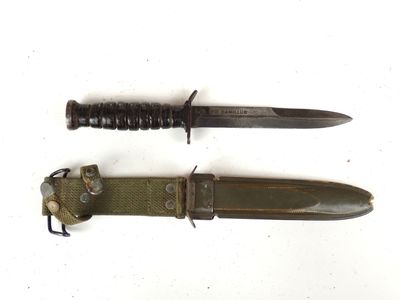 pair of military knifes on a white background with a black handle