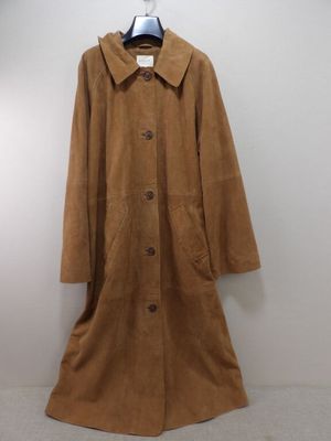 manteau marron suspendu à un cintre dans une pièce blanche