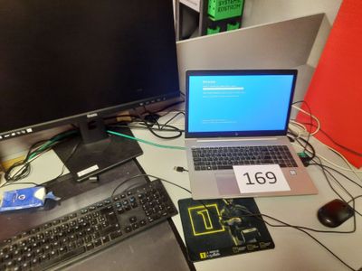 un ordinateur portable posé sur un bureau, à côté d'un écran d'ordinateur