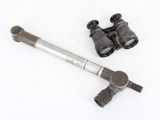 a pair of binoculars and a pipe on a white surface
