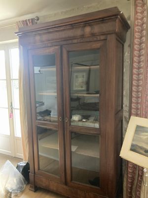 une grande armoire en bois avec des portes vitrées dans un salon