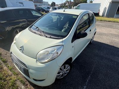 la petite voiture blanche est garée sur le bord de la route