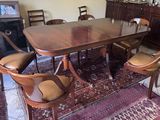 a dining room table with chairs and a rug on the floor