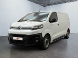 La camionnette blanche est garée dans une grande pièce d'un immeuble.