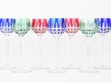 six colorful wine glasses lined up in a row against a white background