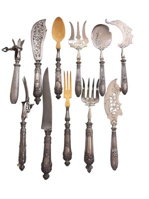 many different types of knives and spoons on the table