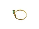 a close up of a gold ring with a green stone