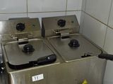 three deep fryers sitting on a table in a kitchen