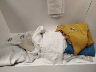 a white bath tub filled with clothes and a towel