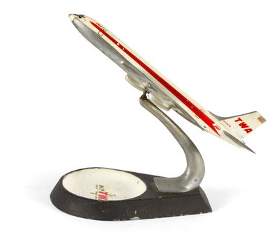 une maquette d'avion posée sur un socle, sur une surface blanche