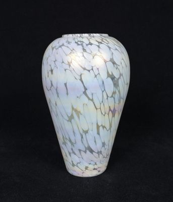 a white and blue vase sitting on a black surface