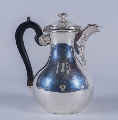 une cafetière ancienne en argent avec une poignée noire sur fond blanc