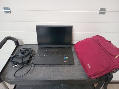 a laptop computer sitting on top of a table with a red bag