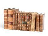several old books stacked on top of each other on a white surface