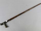 a close up of a wooden stick with a handle on a white surface