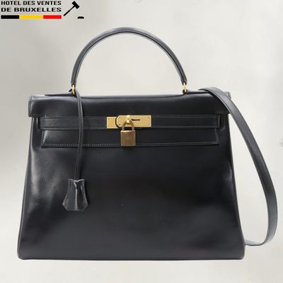 a black leather handbag with a gold lock on the handle