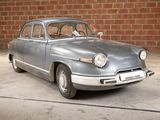 a silver car that is parked in front of a brick wall