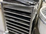 several buckets are stacked on top of a metal cart in a room