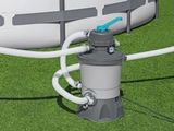 une piscine hors sol blanche et grise à laquelle est raccordé un tuyau d'arrosage
