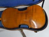 an old violin sits in a blue case on a white surface