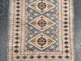 an old rug with fringes on a black floor